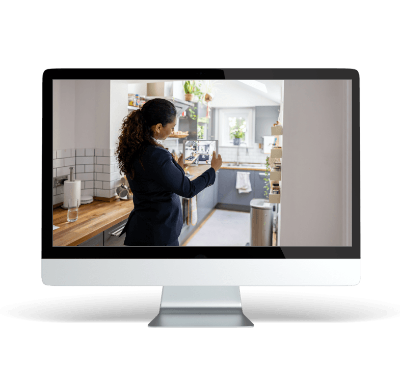 A woman is standing in front of a computer screen.